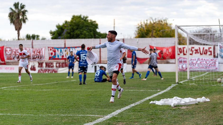 A soccer player celebrates on the field as teammates and opponents watch.