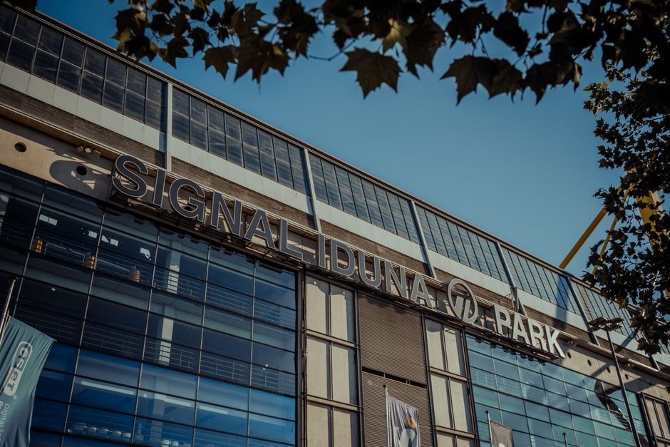 Exterior view of Signal Iduna Park stadium in Dortmund, Germany under clear blue sky.