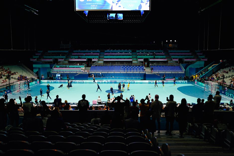 Spectators watching an indoor sports event in a stadium.